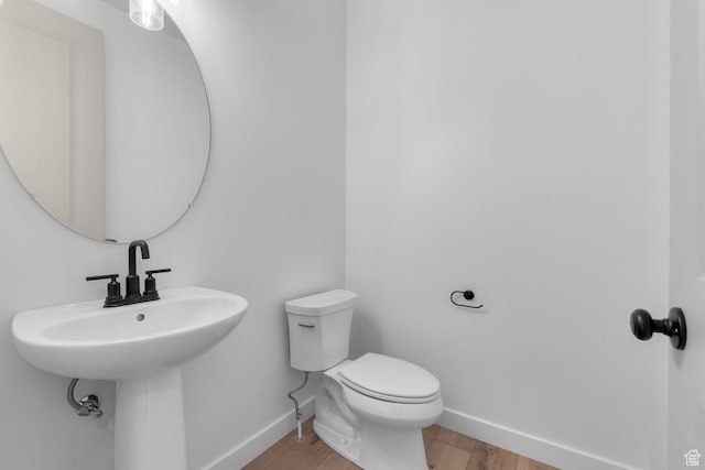 bathroom featuring wood finished floors, toilet, and baseboards