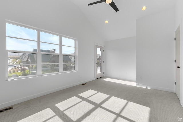 unfurnished room with high vaulted ceiling, baseboards, visible vents, and light colored carpet