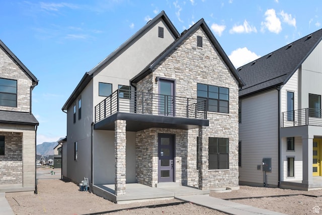 view of front facade featuring a balcony and stucco siding