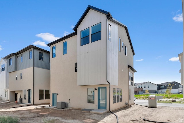 back of house featuring a residential view and central AC
