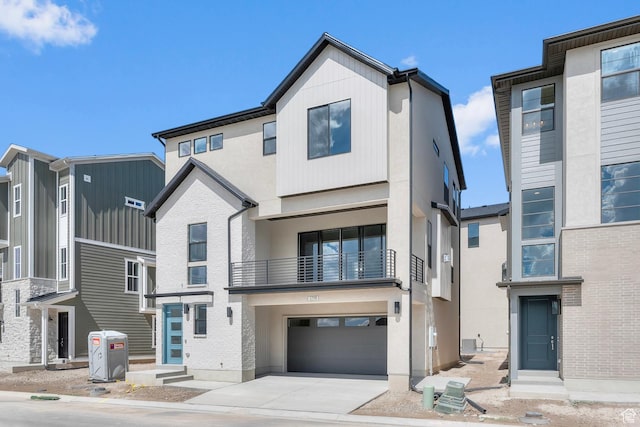 view of front of property with a garage, brick siding, driveway, and stucco siding
