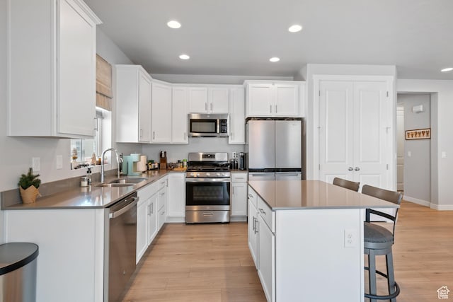 5715 Brambling Way E, Stansbury Park, UT 84074 - kitchen with light wood finished floors, stainless steel appliances, a sink, recessed lighting, and a breakfast bar