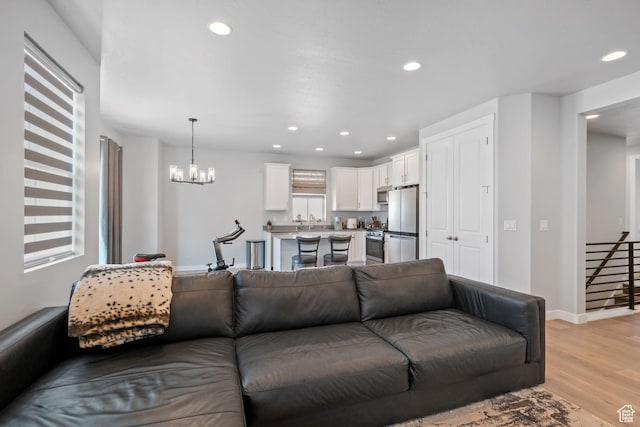 5715 Brambling Way E, Stansbury Park, UT 84074 - living room with baseboards, a notable chandelier, light wood-type flooring, and recessed lighting