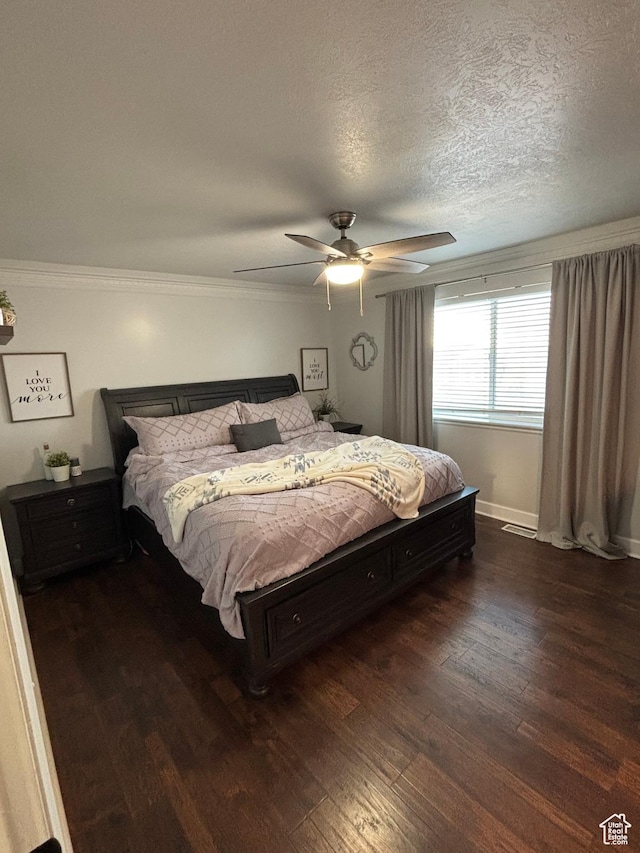 bedroom featuring baseboards, a ceiling fan, ornamental molding, wood finished floors, and a textured ceiling