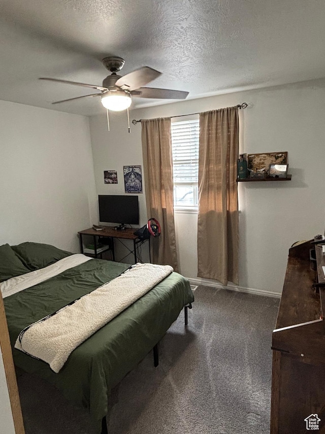 carpeted bedroom with a textured ceiling, a ceiling fan, and baseboards