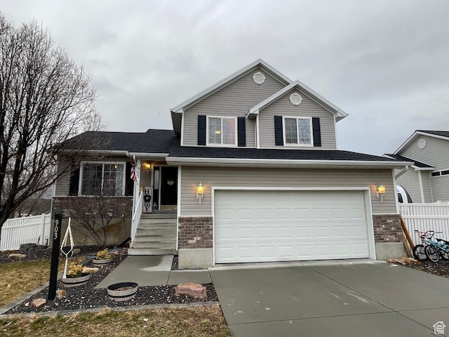 view of front of home with brick siding, fence, driveway, and an attached garage