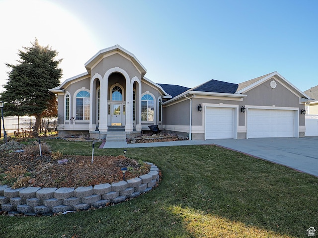 121 E Amber Rd, Saratoga Springs, UT 84045 - view of front facade with an attached garage, concrete driveway, a front lawn, and stucco siding