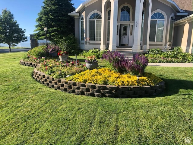 121 E Amber Rd, Saratoga Springs, UT 84045 - view of exterior entry with a yard and stucco siding