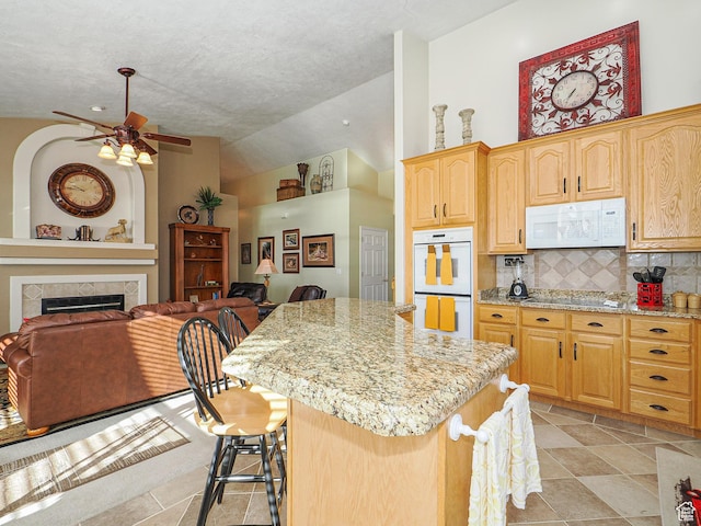 121 E Amber Rd, Saratoga Springs, UT 84045 - kitchen with white appliances, open floor plan, a center island, light stone counters, and lofted ceiling