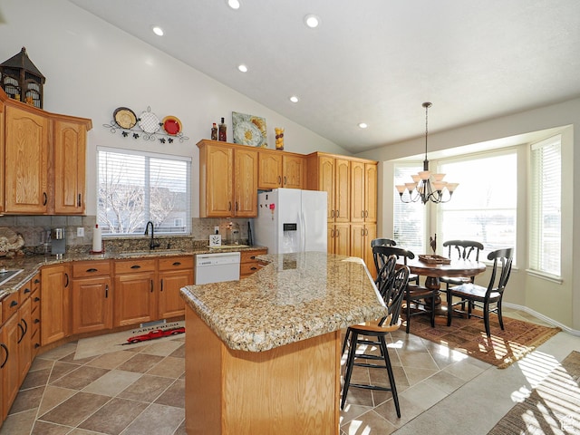 121 E Amber Rd, Saratoga Springs, UT 84045 - kitchen with white appliances, a kitchen island, a chandelier, a sink, and decorative backsplash