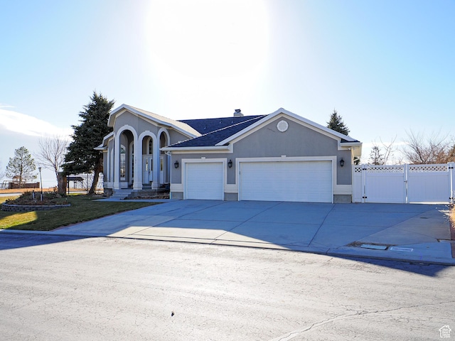 121 E Amber Rd, Saratoga Springs, UT 84045 - view of front of house featuring an attached garage, a gate, driveway, stucco siding, and fence