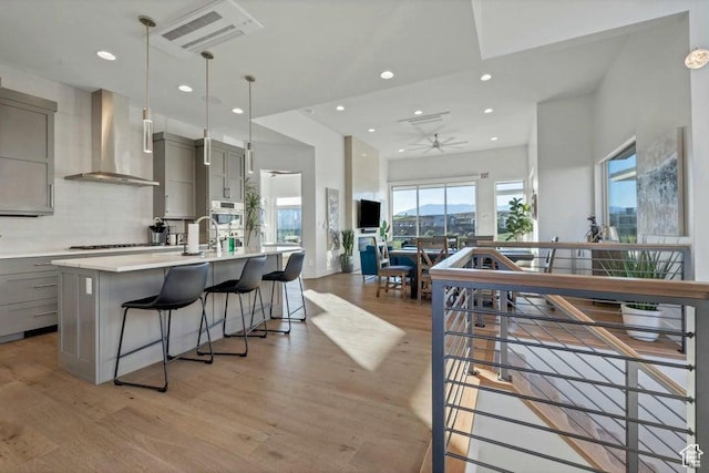 1478 W Torrey Rd, Hurricane, UT 84737 - kitchen with wall chimney range hood, light wood-style floors, and gray cabinetry