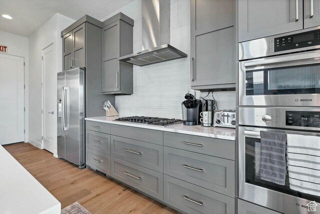 1478 W Torrey Rd, Hurricane, UT 84737 - kitchen with wall chimney range hood, light wood-style flooring, stainless steel appliances, and gray cabinetry