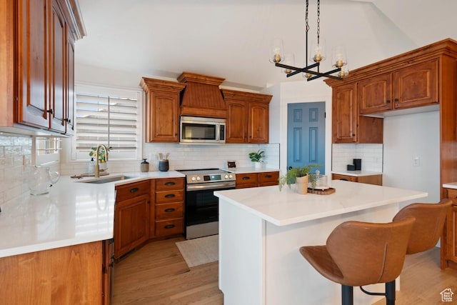 9971 S Dunsinane Dr W, South Jordan, UT 84009 - kitchen featuring light wood-type flooring, appliances with stainless steel finishes, brown cabinets, and a sink