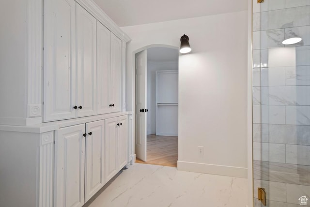 9971 S Dunsinane Dr W, South Jordan, UT 84009 - hallway featuring marble finish floor, baseboards, and arched walkways