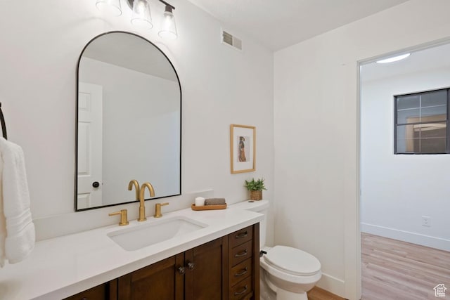 9971 S Dunsinane Dr W, South Jordan, UT 84009 - bathroom featuring toilet, wood finished floors, vanity, visible vents, and baseboards