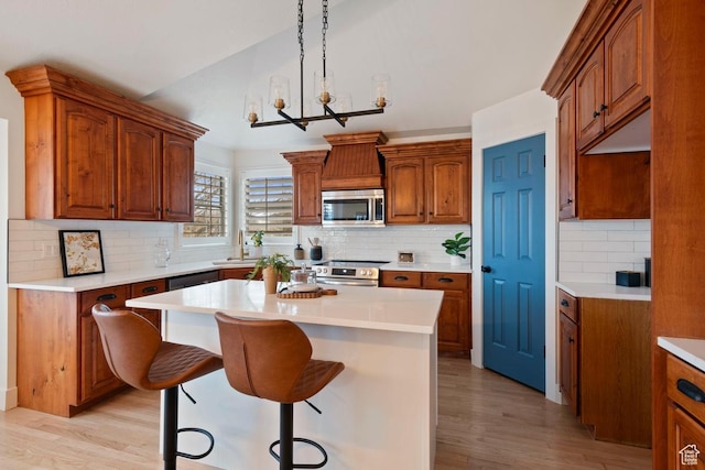 9971 S Dunsinane Dr W, South Jordan, UT 84009 - kitchen featuring a kitchen bar, appliances with stainless steel finishes, brown cabinetry, and a center island