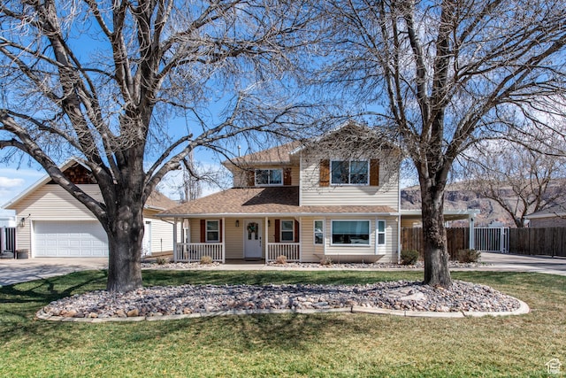 traditional-style home with a porch, a garage, fence, and a front lawn