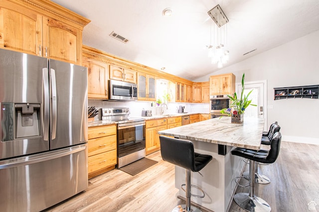 1027 S 920 W, Hurricane, UT 84737 - kitchen featuring visible vents, lofted ceiling, a breakfast bar area, stainless steel appliances, and light brown cabinets