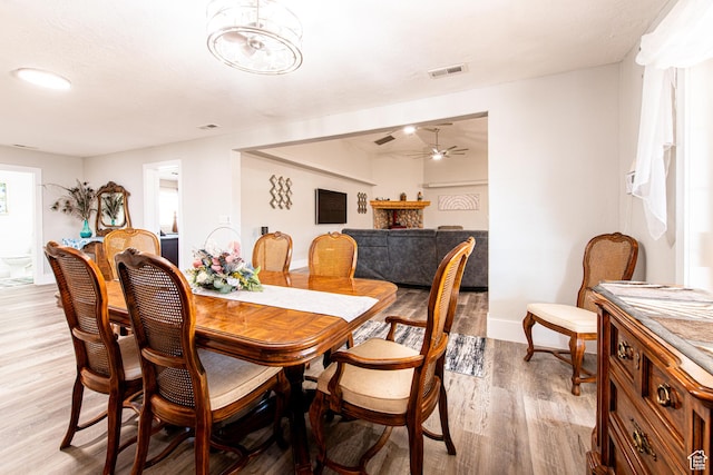 1027 S 920 W, Hurricane, UT 84737 - dining space featuring baseboards, visible vents, a ceiling fan, light wood-style floors, and a fireplace
