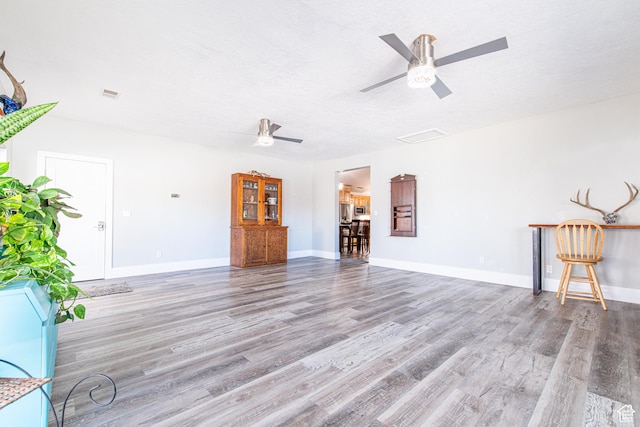 1027 S 920 W, Hurricane, UT 84737 - unfurnished living room featuring ceiling fan, a textured ceiling, baseboards, and wood finished floors