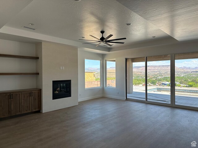 579 S 1800 W, Hurricane, UT 84737 - unfurnished living room with wood finished floors, visible vents, a ceiling fan, baseboards, and a tiled fireplace