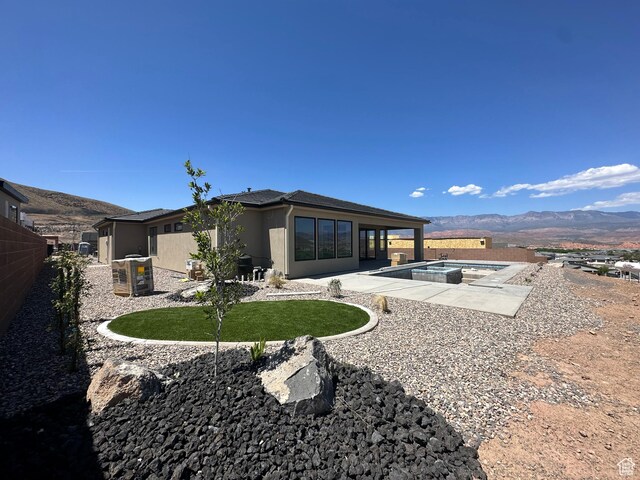 579 S 1800 W, Hurricane, UT 84737 - back of property featuring a mountain view, an in ground hot tub, a patio, an outdoor pool, and stucco siding