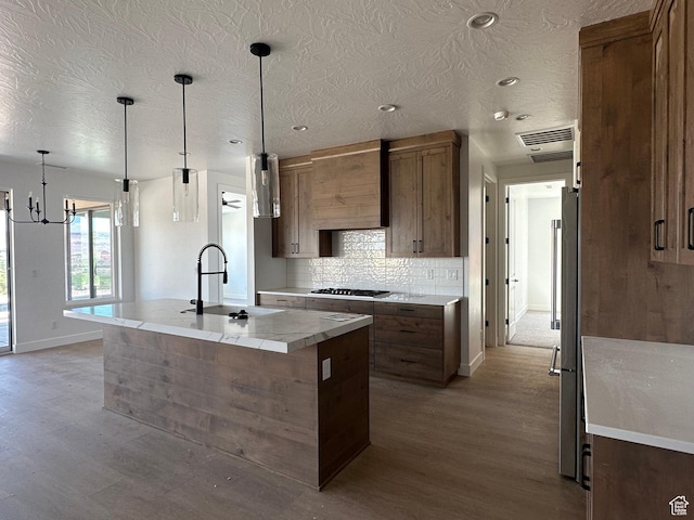579 S 1800 W, Hurricane, UT 84737 - kitchen featuring tasteful backsplash, a sink, an island with sink, light wood-type flooring, and premium range hood