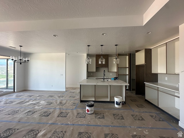 591 S 1800 W, Hurricane, UT 84737 - kitchen with an inviting chandelier, light countertops, modern cabinets, a sink, and a kitchen island with sink