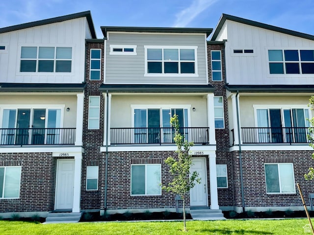 view of front of home featuring board and batten siding and brick siding
