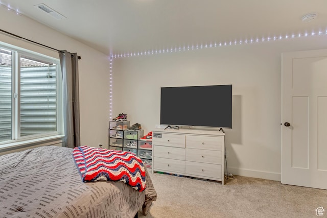 bedroom with baseboards, visible vents, and light colored carpet