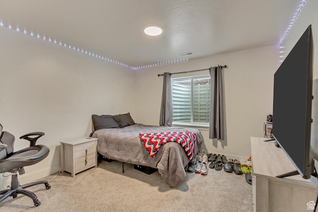 bedroom with light carpet, visible vents, and baseboards