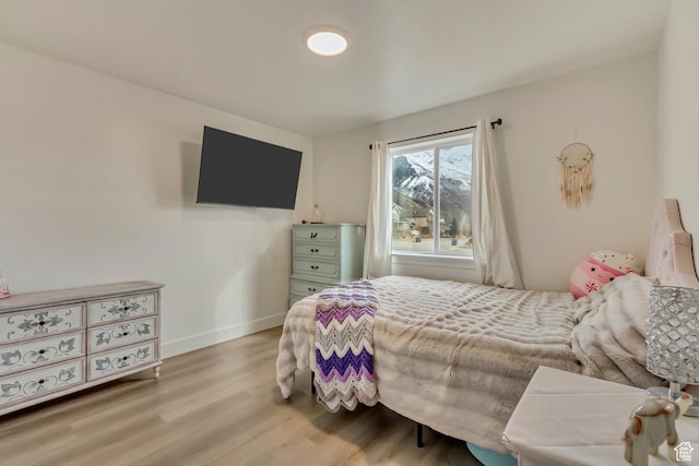 bedroom featuring baseboards and wood finished floors
