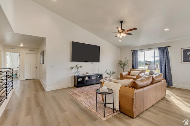 living room featuring visible vents, baseboards, lofted ceiling, ceiling fan, and light wood-style floors