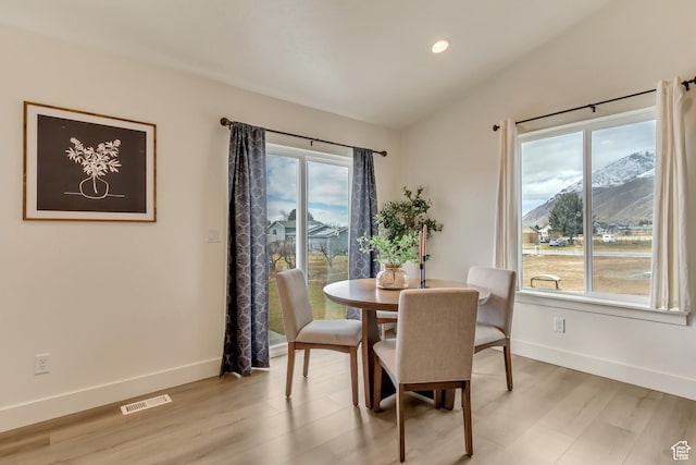 dining room with light wood-type flooring, visible vents, and baseboards