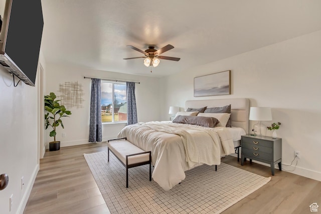 bedroom featuring light wood-style floors, baseboards, and a ceiling fan