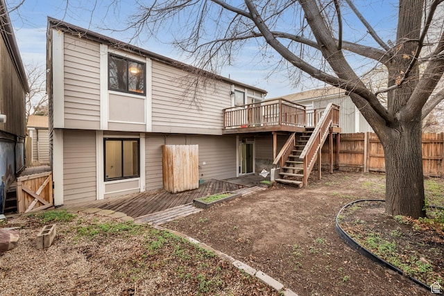 rear view of house with fence, a deck, and stairs