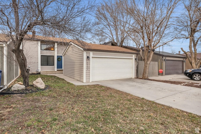 view of front facade with a garage, a front yard, and fence
