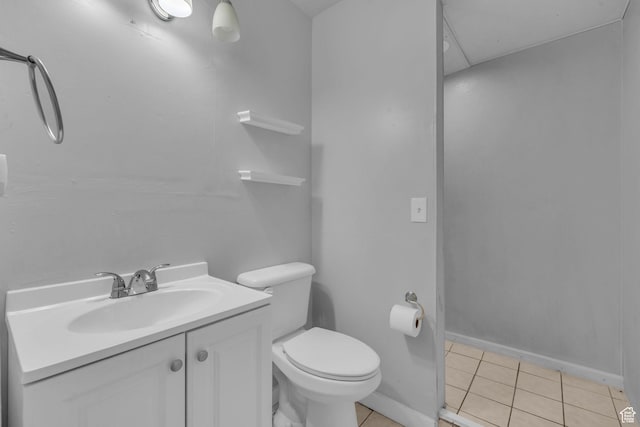 bathroom featuring tile patterned flooring, baseboards, vanity, and toilet