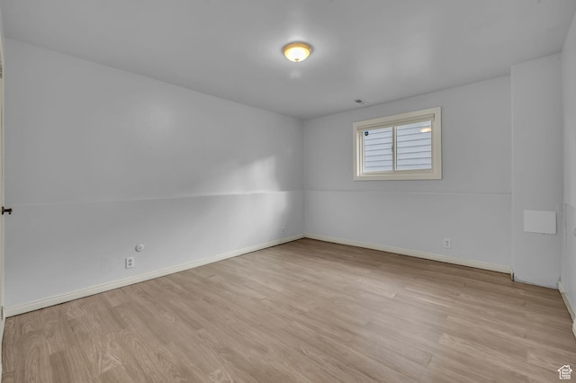 spare room with light wood-style flooring and baseboards