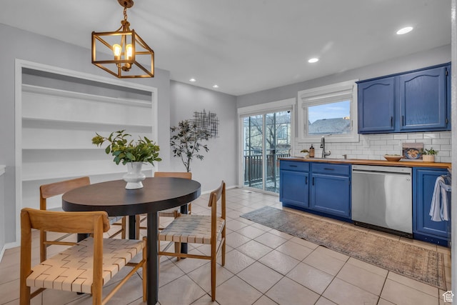 kitchen featuring a sink, wooden counters, blue cabinetry, decorative backsplash, and dishwasher