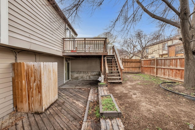wooden deck with a fenced backyard and stairway