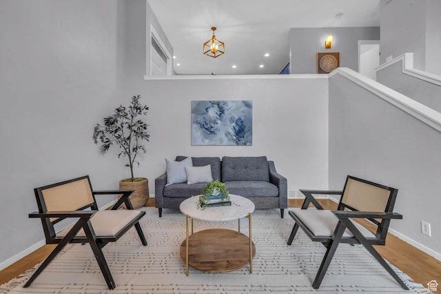 living area with baseboards, wood finished floors, and recessed lighting