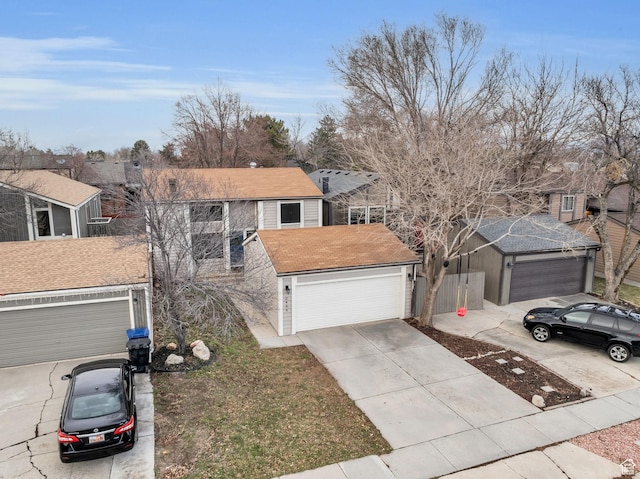 traditional-style house featuring a garage, concrete driveway, and roof with shingles