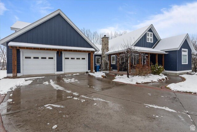 550 N 200 E, Wellsville, UT 84339 - view of front facade featuring driveway, a chimney, board and batten siding, and a garage