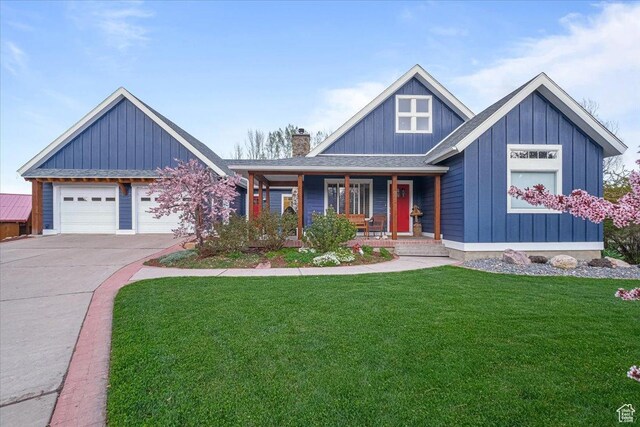 view of front of property featuring board and batten siding, concrete driveway, a front yard, a porch, and a garage