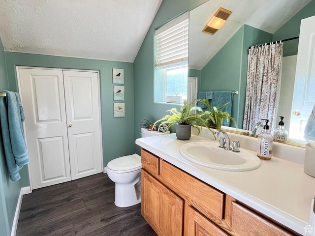 full bath featuring lofted ceiling, toilet, vanity, a textured ceiling, and wood finished floors