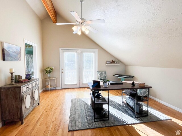 office space with baseboards, a ceiling fan, vaulted ceiling with beams, a textured ceiling, and light wood-style floors