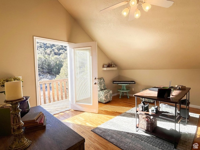 office featuring baseboards, lofted ceiling, ceiling fan, wood finished floors, and a textured ceiling