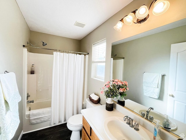 bathroom featuring visible vents, toilet, shower / tub combo, vanity, and wood finished floors